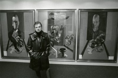 Francis Bacon devant son triptyque intitulé Triptych (1976), Galerie Claude Bernard, Paris, 1977.Photo et © John Minihan MB Art Collection